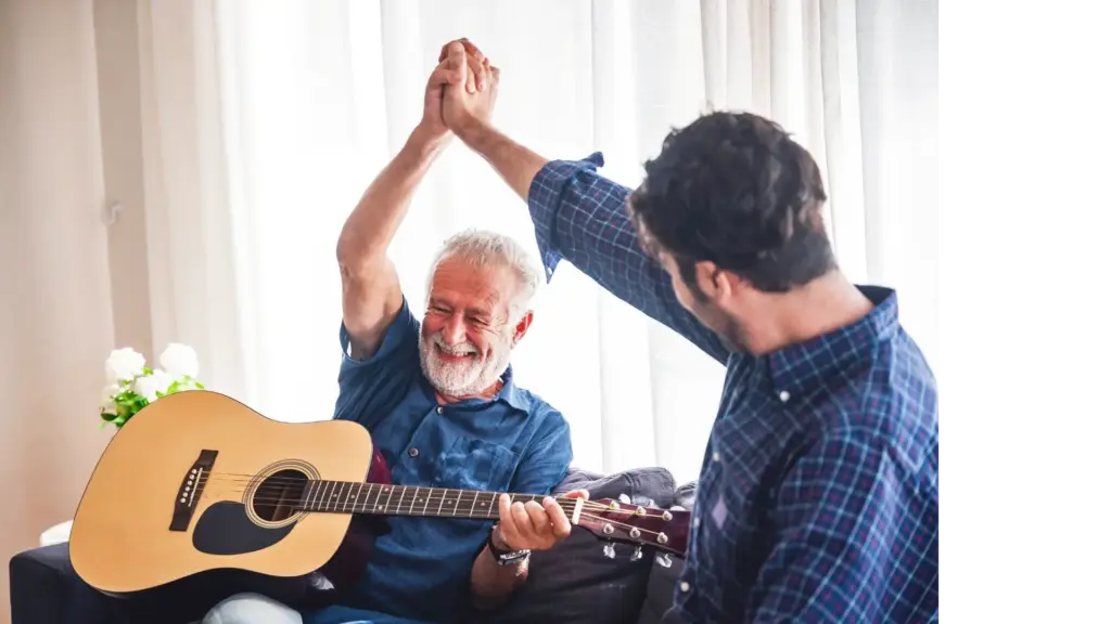 Picture of an elderly patient with his son, playing the guitar.