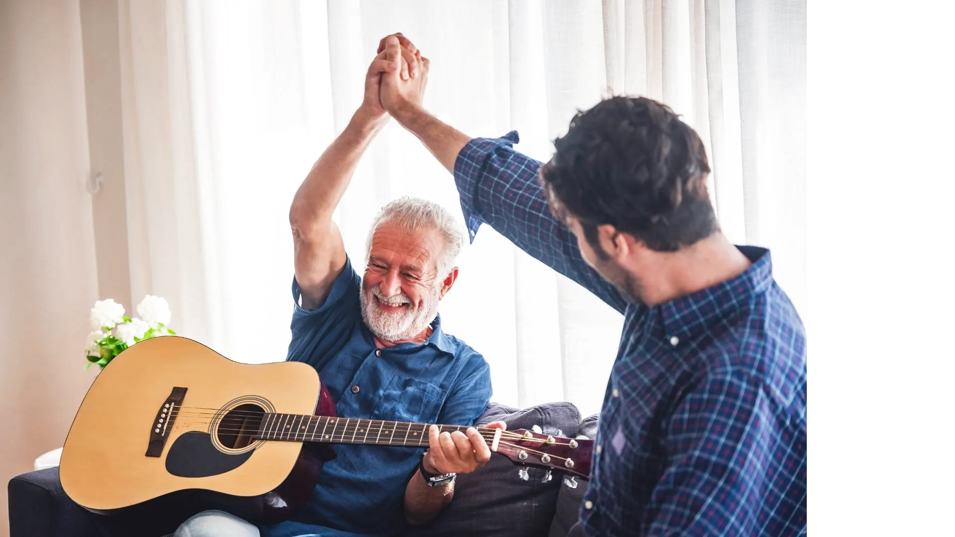 Picture of an elderly patient with his son, playing the guitar.
