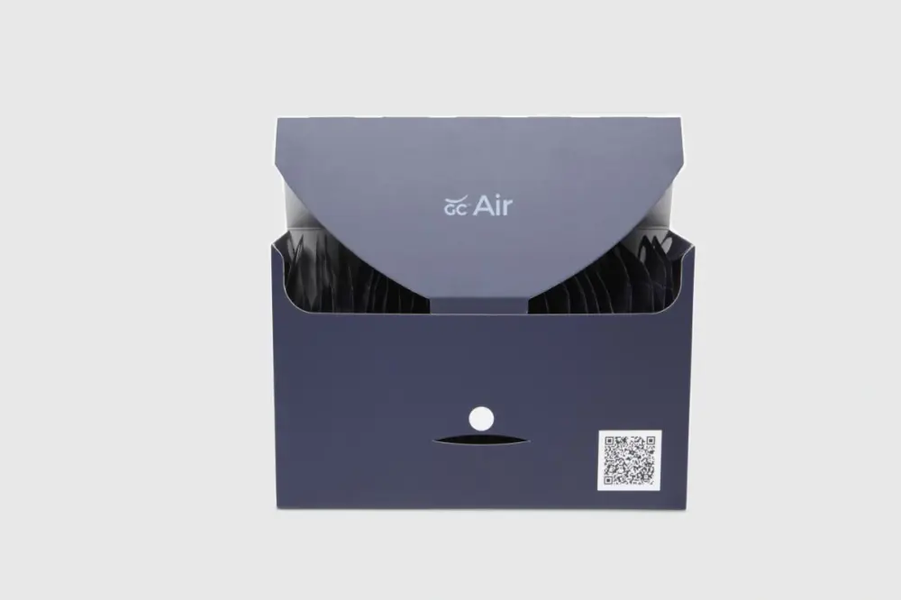 Photograph of the sleek blue box for GC Air (GentleCath Air). Box is open and you can see some of the images of the catheter bags for the GentleCath Air. Box has the logo for the GC Air in the middle and a QR code on the bottom right