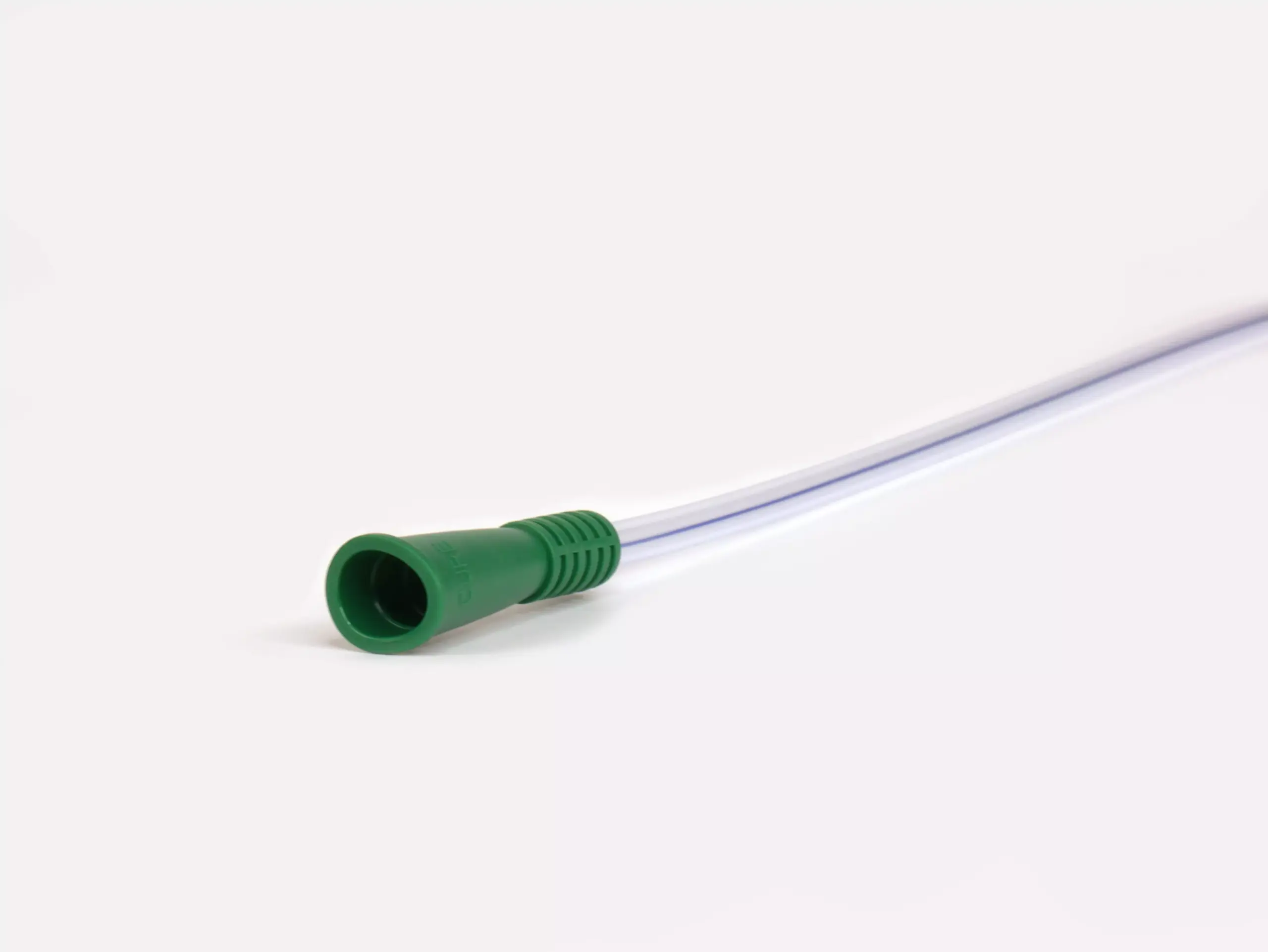 Macro shot highlighting the intricate details at the base of a Cure brand catheter by RA Fischer Co., accentuated by its green grip.