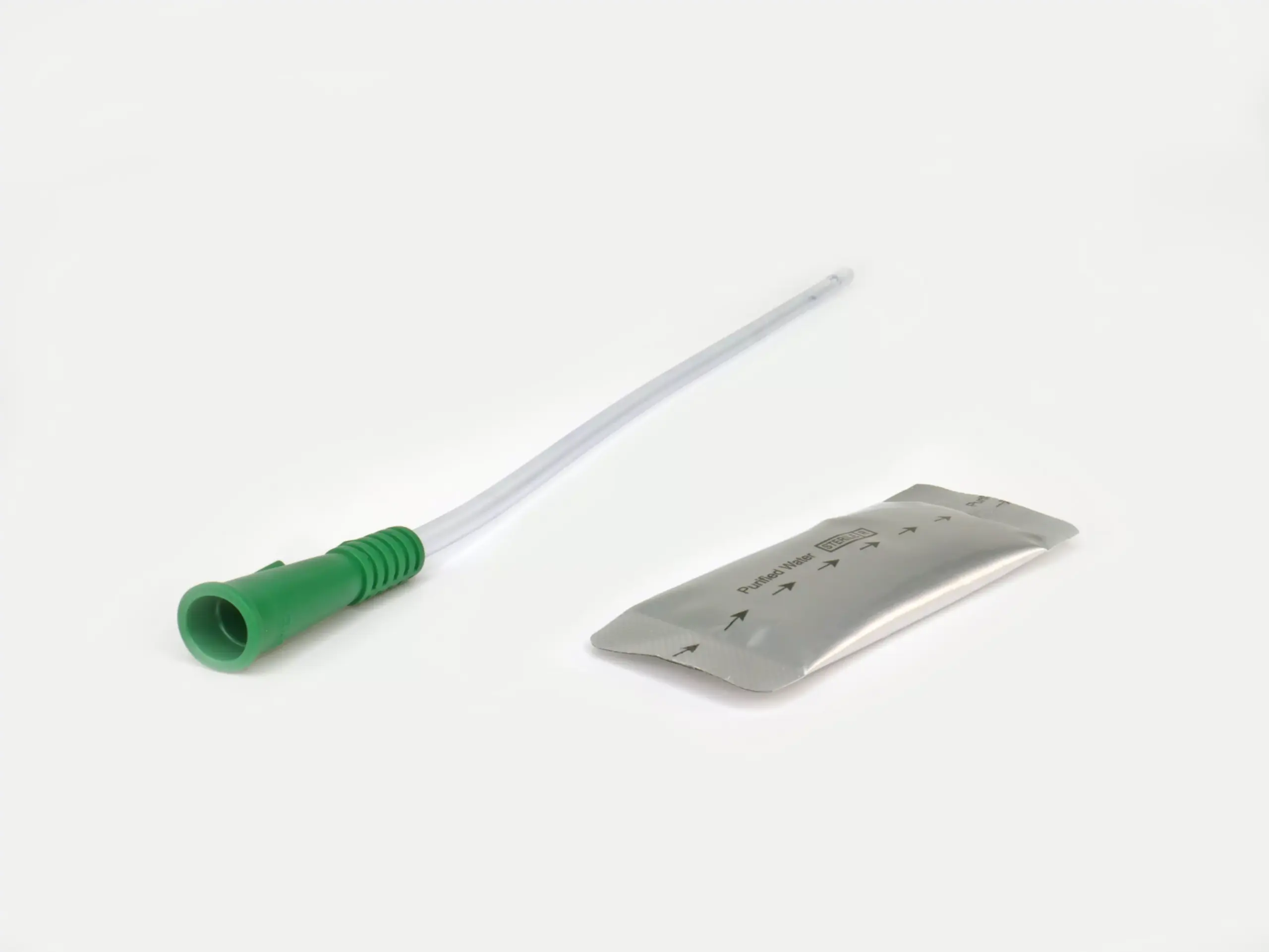A close-up product photograph featuring one of RA Fischer Co.'s urological catheters from the Cure brand. The catheter is equipped with a green gripper and is positioned next to a silver water packet, emphasizing its key features.