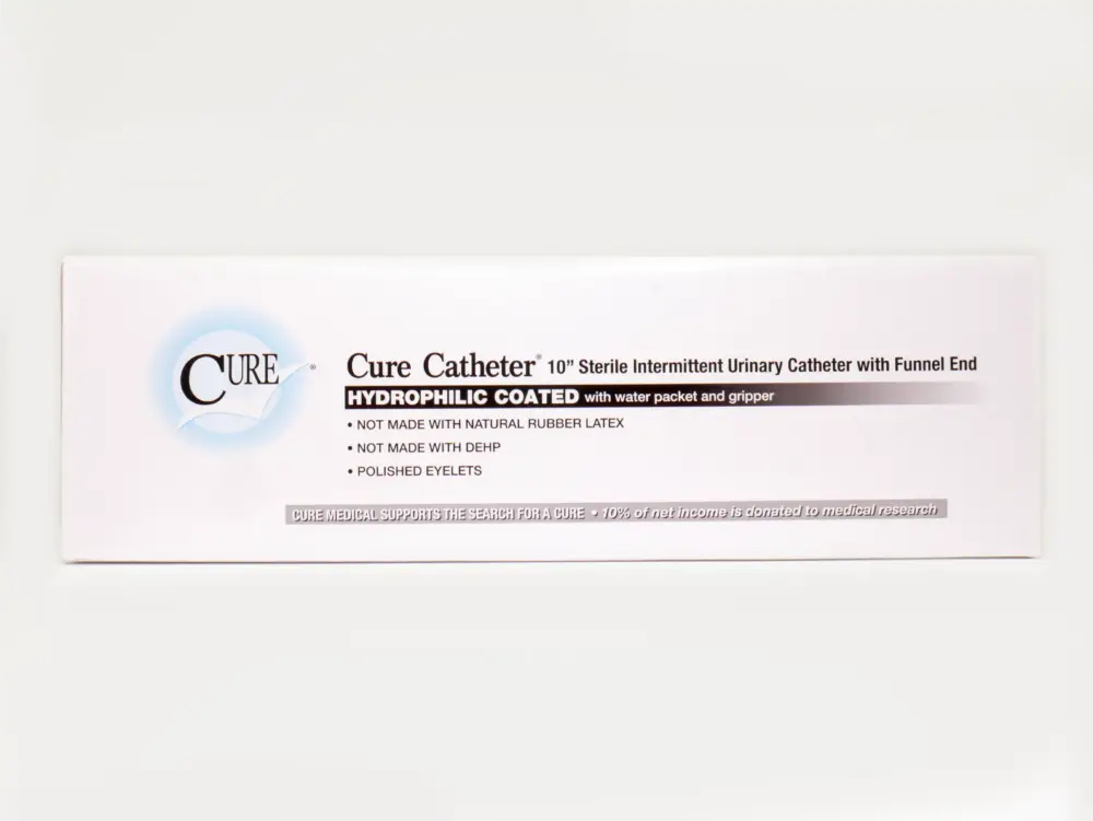 Photograph of a package of RA Fischer Co.'s Cure Catheters, Hydrophilic coated, White box on white background. Package reads "Cure Catheter 10" sterile intermittent urinary catheter with funnel end. Hydrophilic coated with water packet and gripper. Not made with natural rubber latex. Not made with DEHP. Polished eyelets."