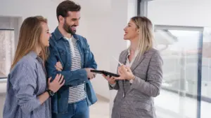 Picture of two patients laughing and smiling with their realtor while shopping for a new home.