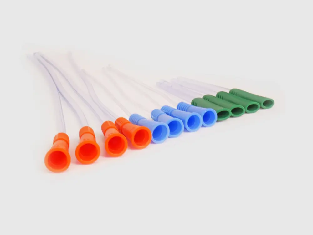 Photograph of an assortment of twelve RA Fischer Co. catheters of deferring lengths and gripper sleeve colors. The catheters are lined up. Green gripper catheters are shorter than the others. Grippers are facing camera. Gripper colors are blue green orange. White background