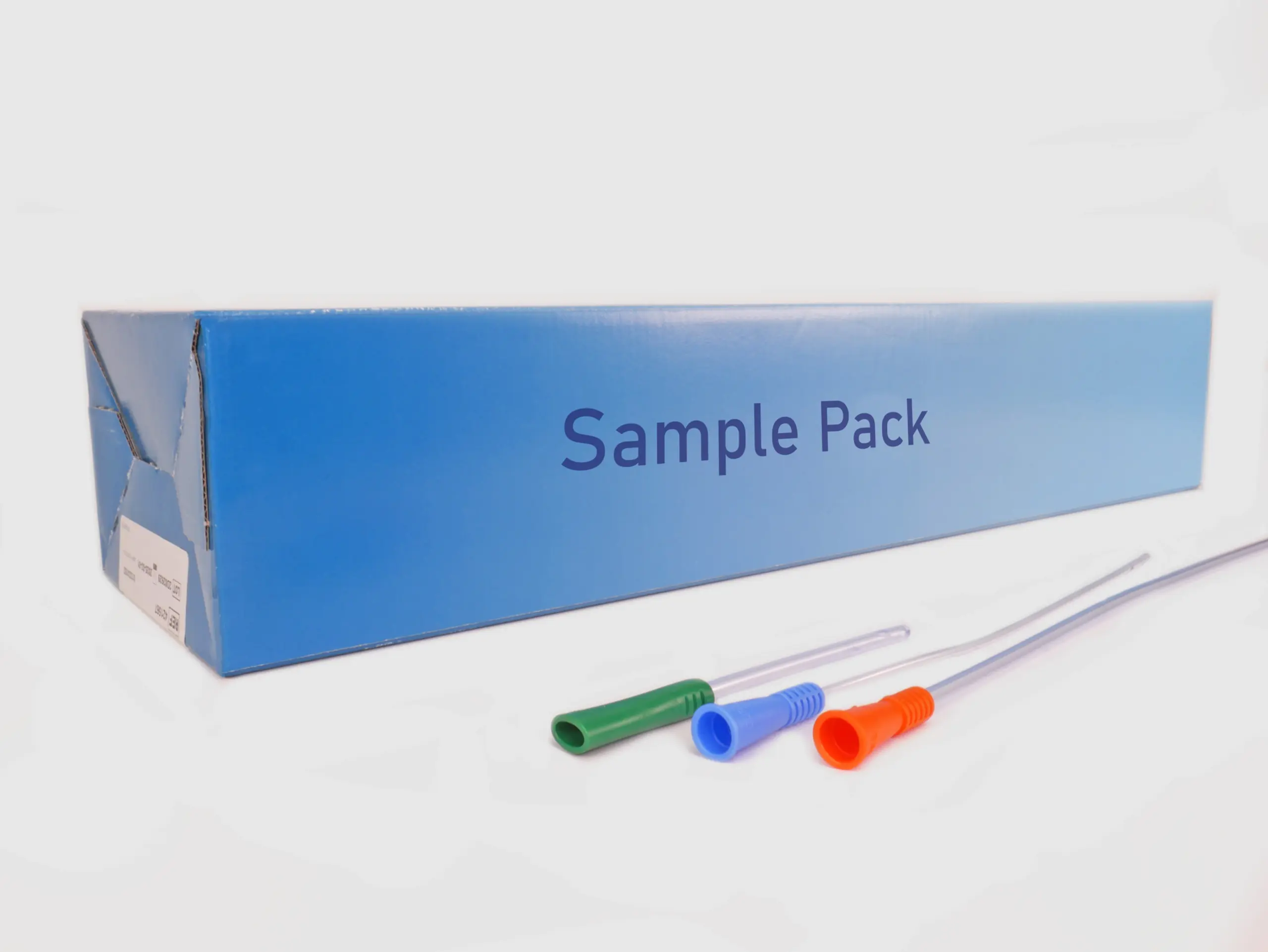 Photograph of a box for the "3-Day Free Sample Pack" of catheters from RA Fischer Co. Box is light blue and reads "Sample Pack." In front of the box are three catheters of differing lengths. The colors of the grippers are green, blue, and orange