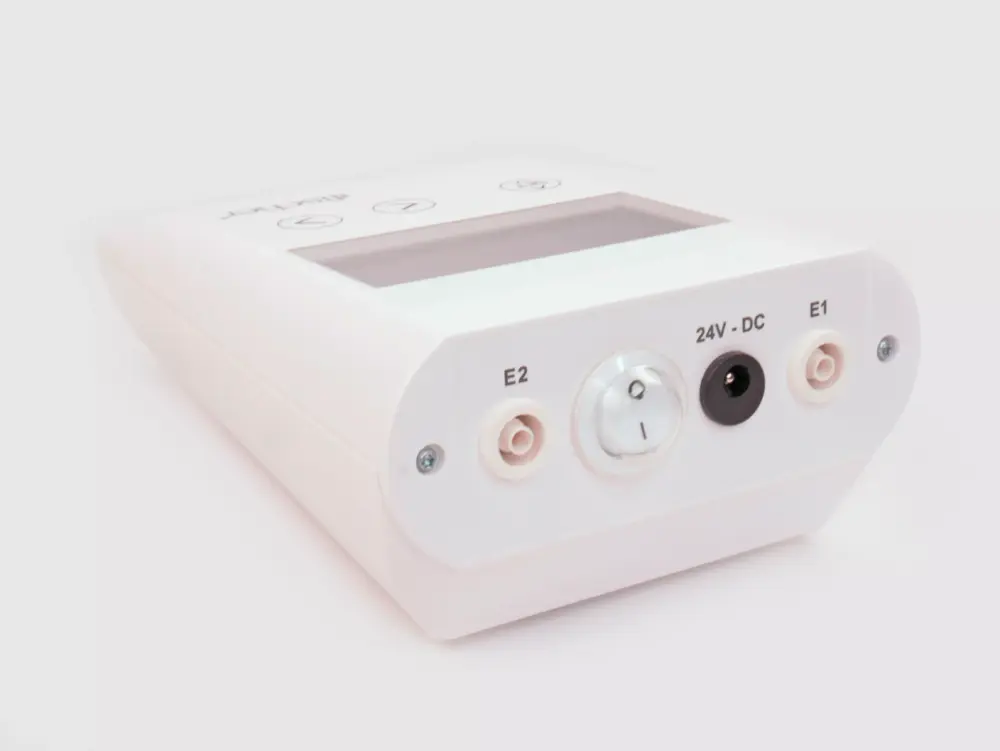 A detailed photograph capturing the rear side of RA Fischer's 'The Fischer' Device, featuring the white, rectangular 'main control unit.' This specialized iontophoresis device is meticulously tailored for the effective treatment of hyperhidrosis (excessive sweating). The image provides a clear view of the power switch and the ports where the electrodes are plugged in. The background is a crisp white. [ Iontophoresis Device for Sweating ]