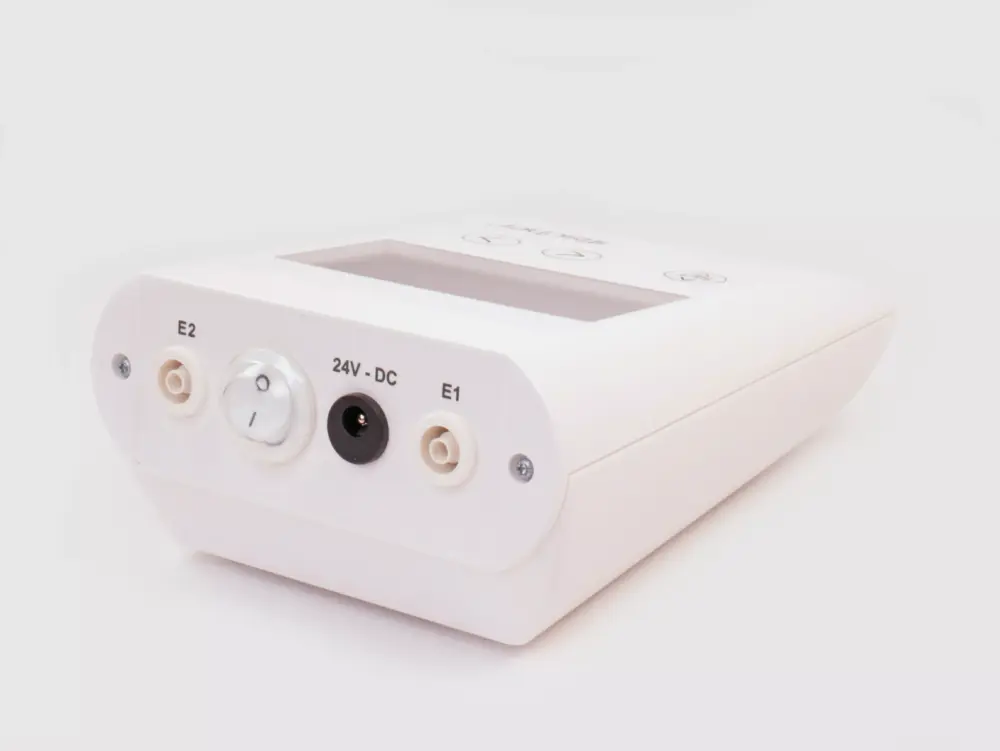 Photograph of the rear side of RA Fischer's 'The Fischer' Device, showcasing the white, rectangular 'main control unit.' This iontophoresis device is meticulously designed for the treatment of hyperhidrosis (excessive sweating). In the image, you can clearly see the power switch and the ports where the electrodes plug in. The background is a clean white. [ Iontophoresis Device for Sweating ]