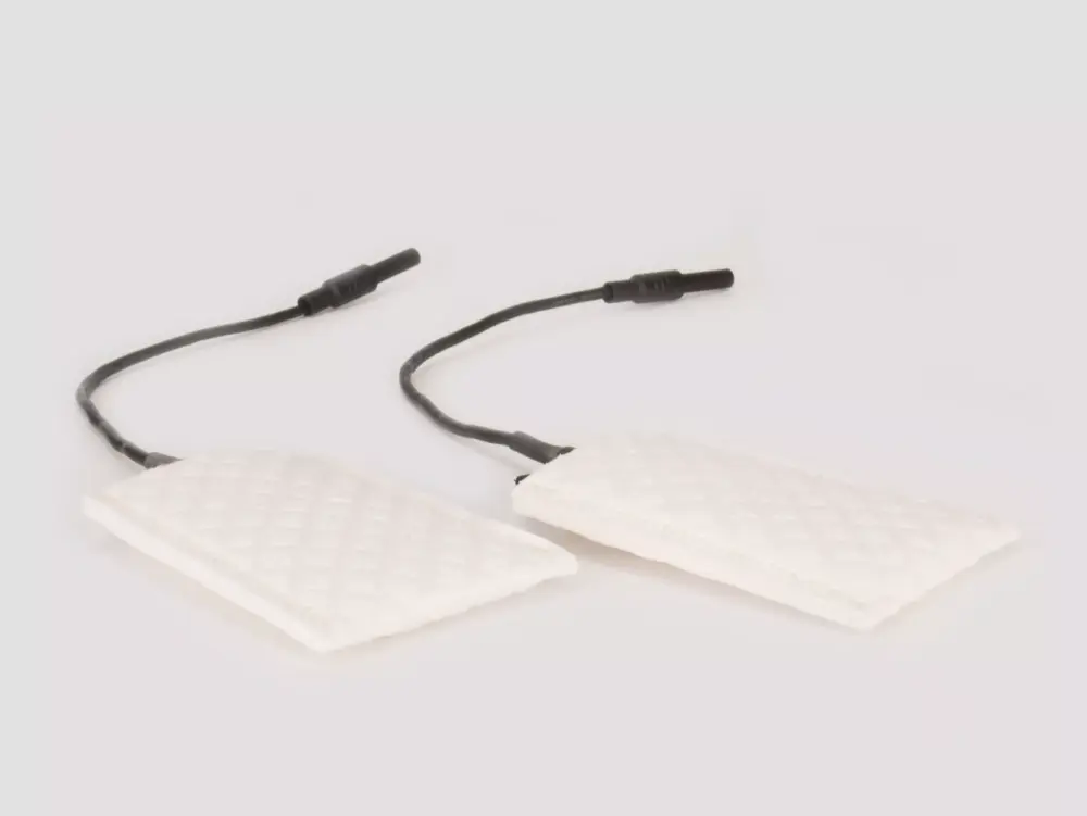 A detailed photograph featuring the metal-free silicone underarm attachments of RA Fischer's 'The Fischer' Device—an iontophoresis device intricately designed for the treatment of hyperhidrosis (excessive sweating). These attachments contain small black electrodes enclosed within white, textile-like sleeves. Their purpose is specifically geared toward the management of axillary (underarm) hyperhidrosis. [ Iontophoresis Device for Sweating ]